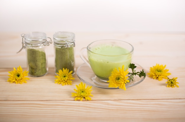 Matcha latte en una taza con polvo de matcha