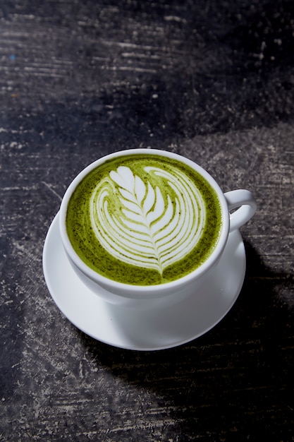 Foto matcha-tee latte auf schwarzer tabelle