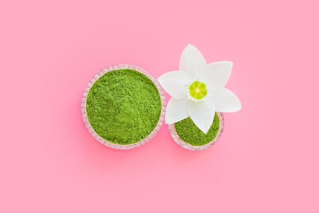 Matcha trockenes grünes Pulver auf einer rosa Oberfläche für die Herstellung von japanischem Naturtee.