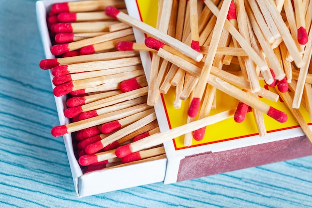 Matchstick fuera de caja de cerillas en la mesa de madera de color.