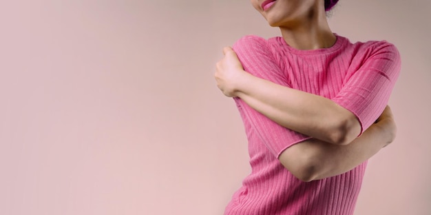 Ámate a ti mismo concepto. Mujer sonriente abrazándose y abrazándose a sí misma. Mente positiva. Bienestar Salud Mental. Soltero en el día de San Valentín. Tono de color rosa