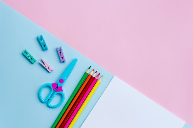 Material de escritório em um fundo rosa e azul. Trabalhe em casa.