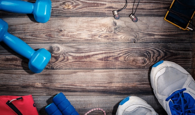 Material deportivo en la mesa de madera, vista superior. Punto de luz en el centro de la mesa de madera con espacio vacío para texto, logotipo u otra cosa.