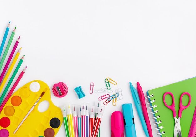 Foto material escolar colorido e artigos de papelaria em fundo branco. copie o espaço, vista superior. volta ao conceito de escola.