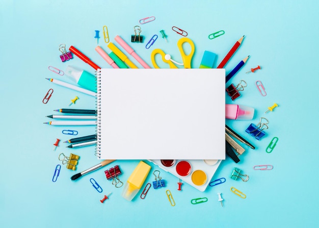 Material escolar e caderno vazio em bckg azul