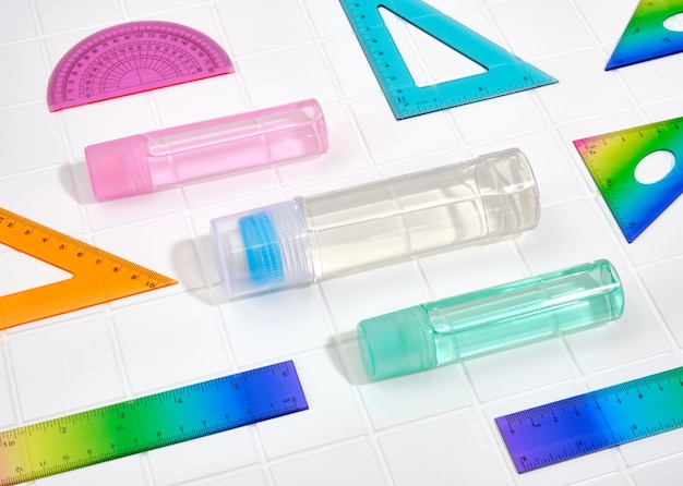 Material escolar e de escritório Composição de linhas multicoloridas e frascos de cola de escritório na mesa