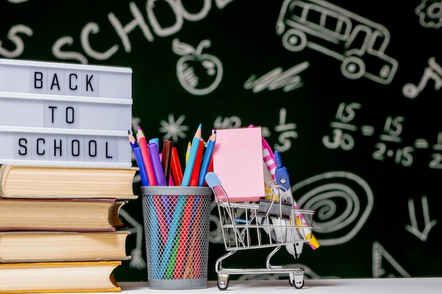 Material escolar e livros na parede pintada