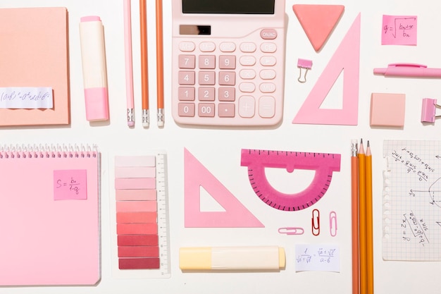 Material escolar nas cores rosa em um fundo branco preparação para a escola