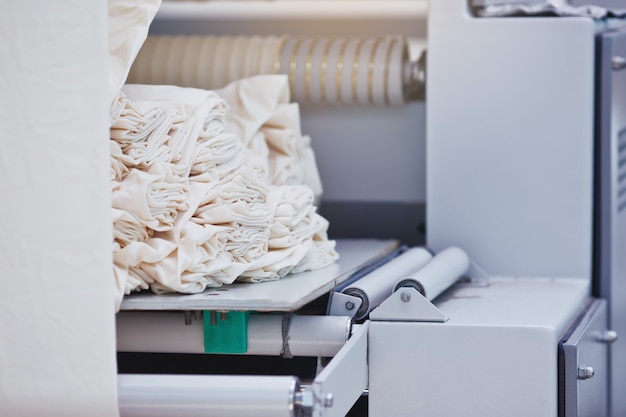 Material in der Textilfabrik Rollen aus industriellem Baumwollgewebe für die Textilherstellung von Bekleidungsstoffen auf der Maschine