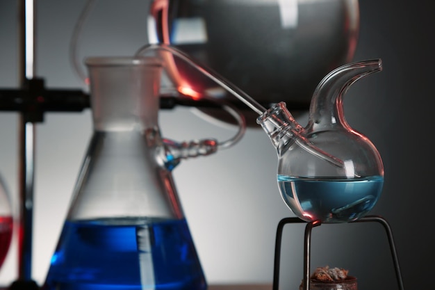 Material de vidrio de laboratorio fijo en soporte sobre fondo de colores oscuros