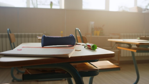 Materiales escolares en el escritorio del aula Cuaderno y estuche de lápices en la mesa