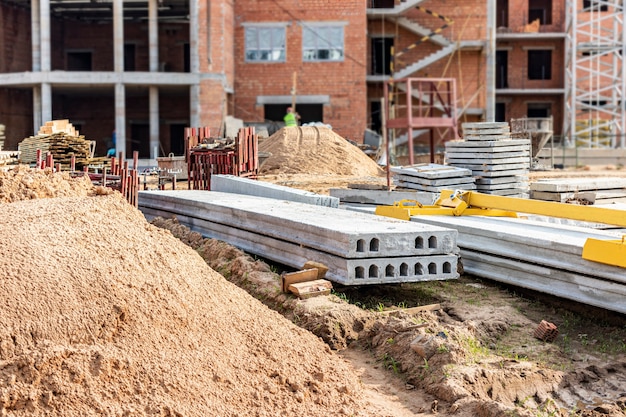 Materiallagerung auf der Baustelle. Stahlbetonplatten für den Bau. Errichtung eines Gebäudes aus Blöcken.