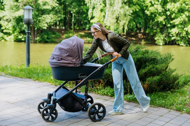 Maternidad un paseo por el parque una madre joven