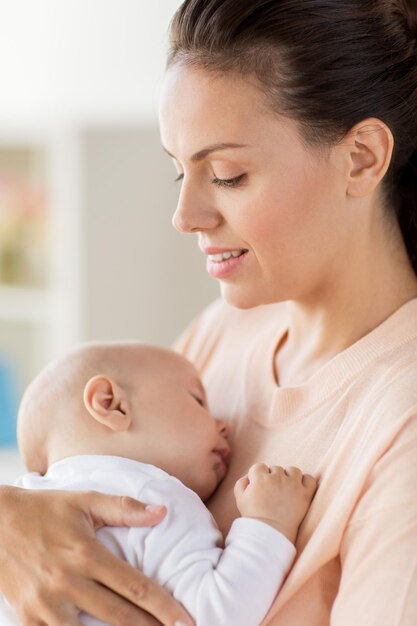 maternidad y personas concepto de primer plano de la madre sosteniendo a un bebé durmiente en casa