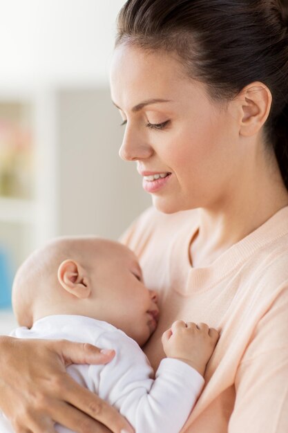 maternidade e pessoas conceito de close-up de mãe segurando o bebê dormindo em casa