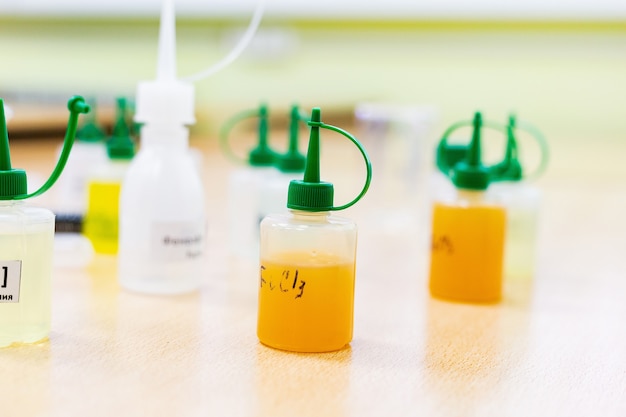 Matraz de la industria química con tubos de ensayo de laboratorio líquido están sobre la mesa en el laboratorio