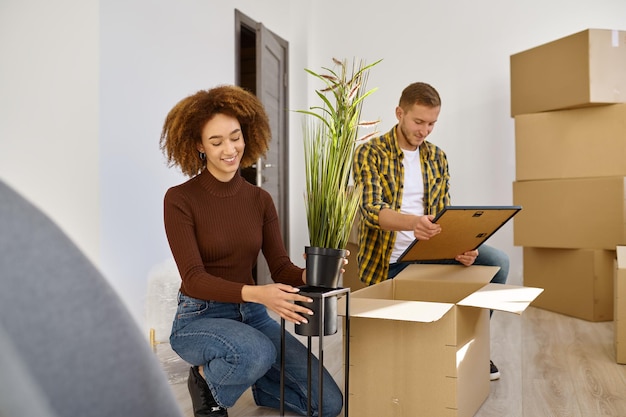 Matrimonio joven arreglando su nuevo apartamento. Esposa y esposo desempacando cosas