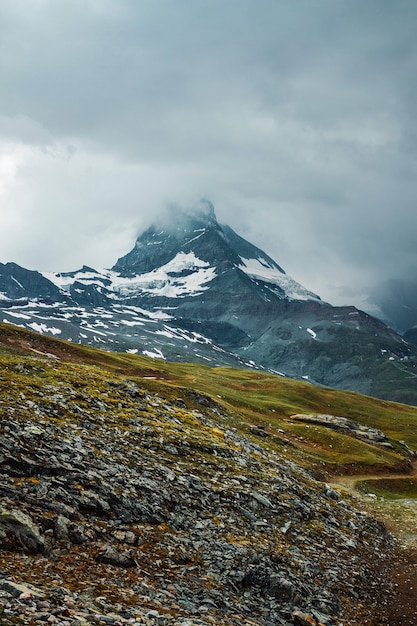 Matterhorn en nubes ountain path hierba piedras Zermatt Alpes Suizos Aventura en Suiza