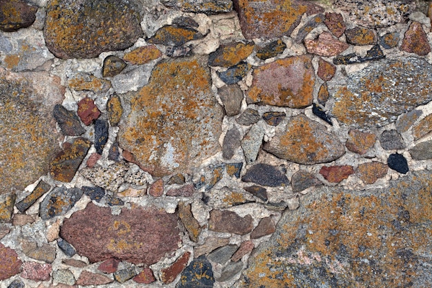 Mauer der mittelalterlichen Burg mit Steinen und roten Ziegeln