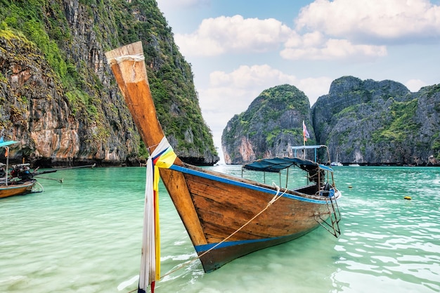 Maya Bay con bote de cola larga de madera rodeado de montañas de piedra caliza en el mar tropical de Andaman