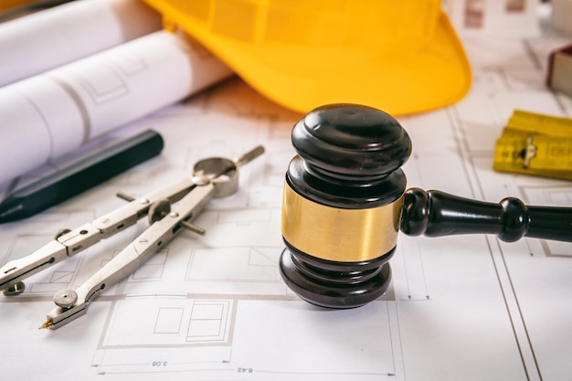 Mazo de juez de derecho laboral y de construcción y herramientas de diseño en el plano de construcción de cerca