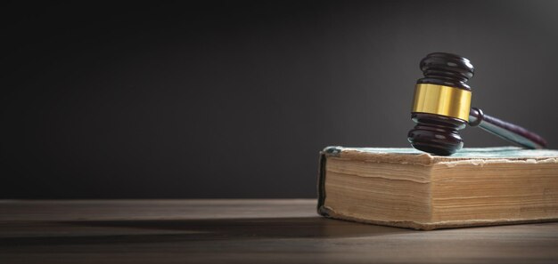 Mazo de juez y libro sobre la mesa de madera