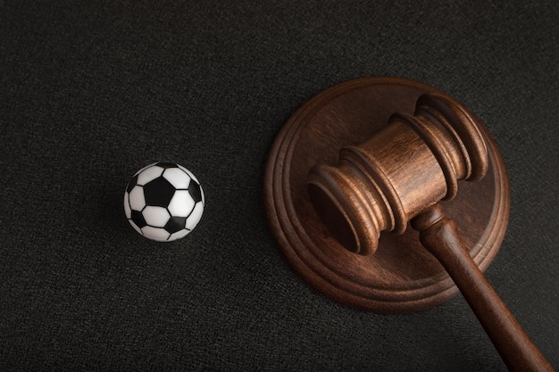 Mazo de juez de madera y pelota de fútbol de juguete Entrenador de fútbol acusado Demanda por conmoción cerebral