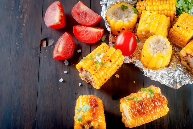 Mazorcas de maíz a la plancha con solt, especias y tomates.