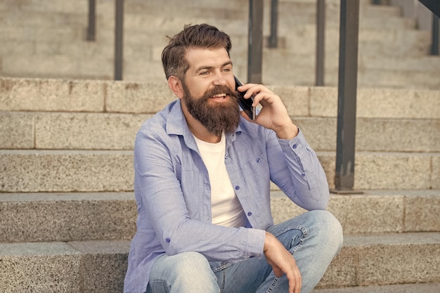 Me alegro de que el hombre tenga un teléfono inteligente llamada al aire libre el hombre tiene una llamada de teléfono inteligente fuera del hombre tiene una chamada de teléfono inteligente en la calle foto del hombre tiene llamadas de teléfono inteligente