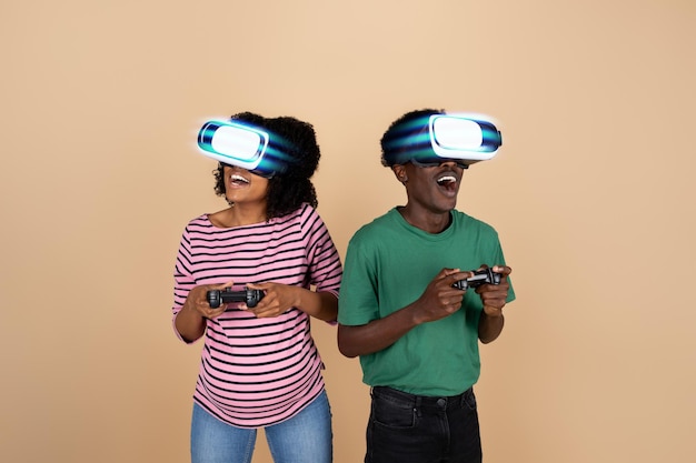 Me alegro de que la joven familia negra sorprendida con el vientre en gafas vr juegue en línea con joysticks