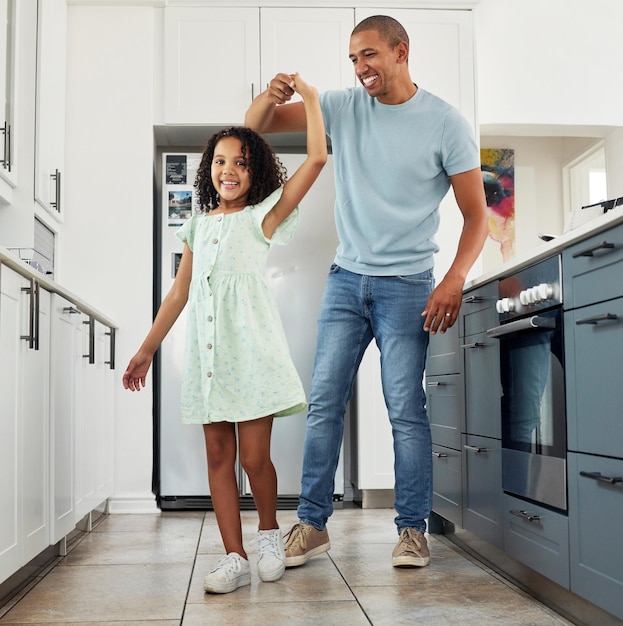 Me encanta la cocina y papá bailando con un niño en un hogar para cuidar la felicidad y unirse en una casa Riendo padre y padre jugando con una niña o un niño como apoyo girando con energía