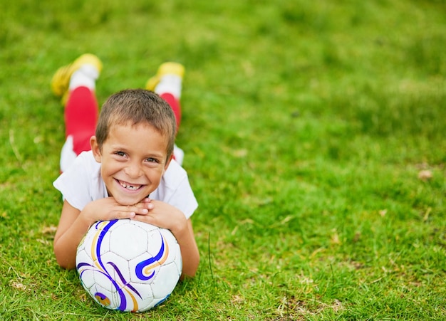 Me encanta el fútbol Retrato de un niño jugando al fútbol afuera