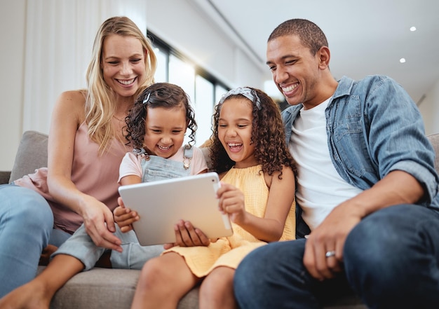 Me encanta el sofá y la familia con tabletas para niños o redes sociales para transmitir interracial o reír juntos Padre o madre digital con dispositivo para niñas o ver videos divertidos y padres felices