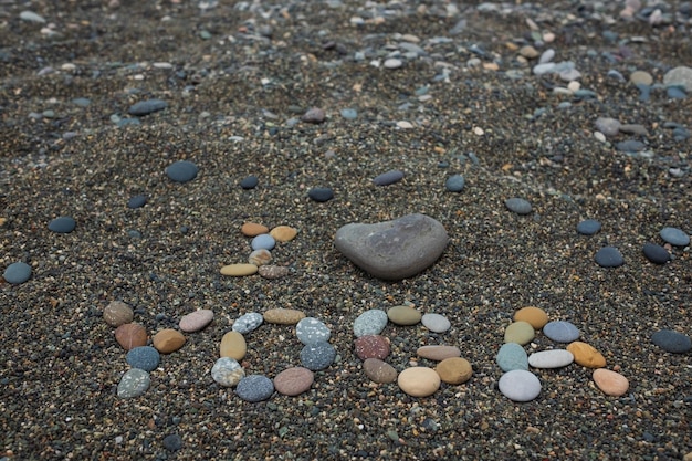 Me encanta el texto de yoga hecho de piedras en la playa