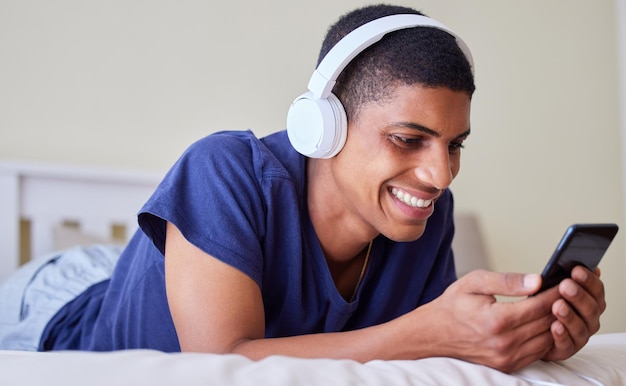 Me encanta ver videos y escuchar música Foto de un joven usando su teléfono en casa