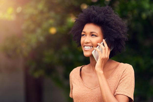 Me siento tan conectada con la naturaleza Foto de una mujer joven hablando por su celular mientras pasa el día al aire libre