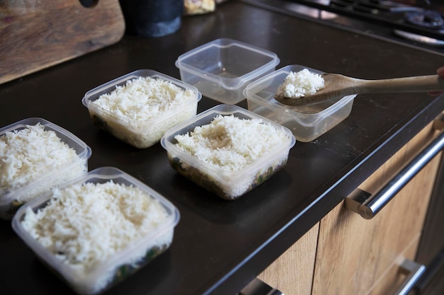 Meal Prep Stapel von hausgemachten Reis- und Hähnchengerichten in Behältern, die für später eingefroren werden können