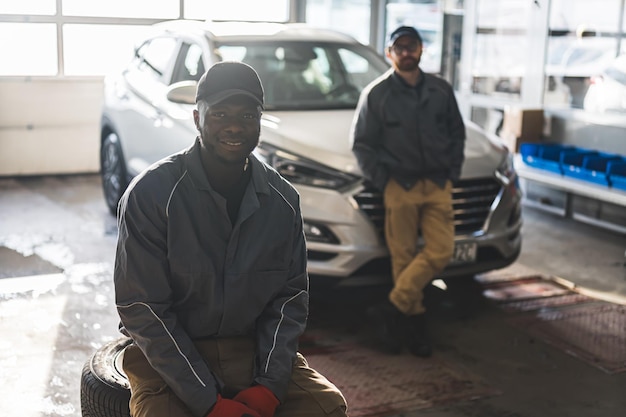 Mecânica de automóveis de dois homens em uma oficina de reparação