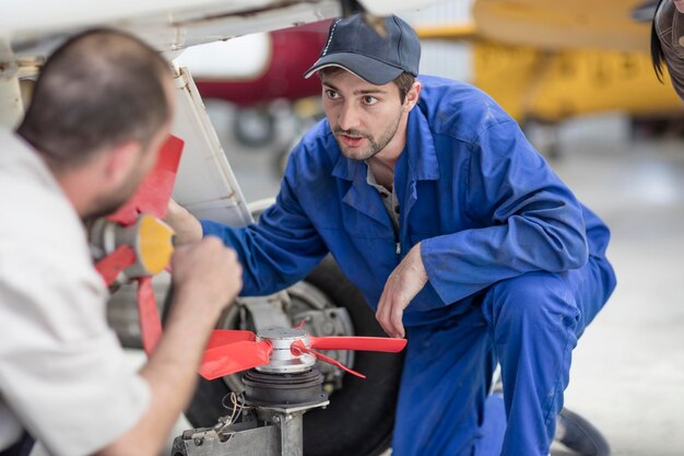 Mecânica em hangar reparando aeronaves leves