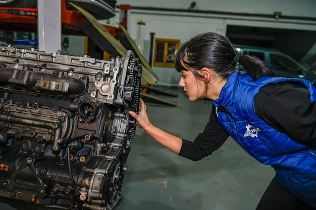 Mecânica jovem trabalhando no reparo de um motor de carro