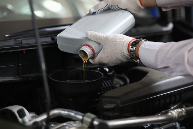 Mecánico agregando aceite al auto