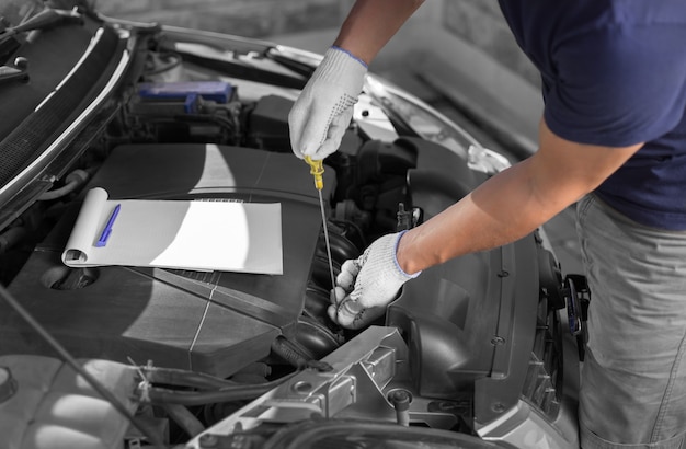 Mecánico de automóviles comprobando el nivel de aceite en el motor del automóvil