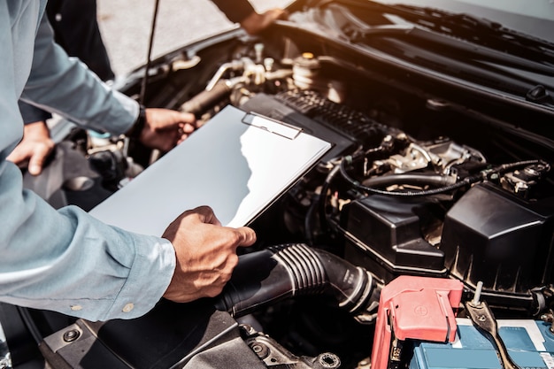 Mecánico de automóviles con lista de verificación para sistemas de motor de automóvil después de la reparación