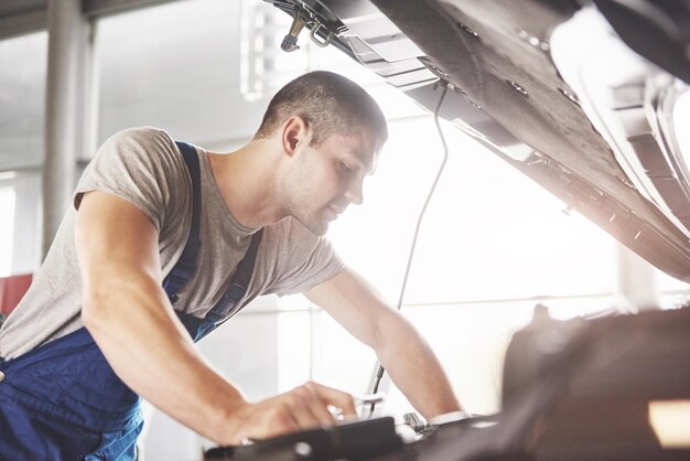 Mecánico de automóviles que trabaja en garaje Servicio de reparación