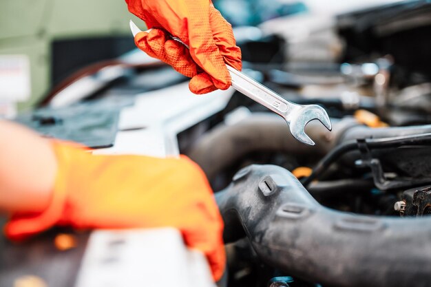 Mecánico de automóviles que trabaja en el motor de servicio de reparación de garaje