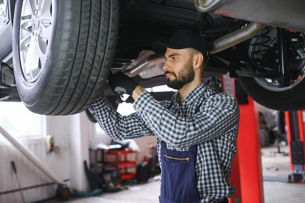 Mecánico de automóviles que trabaja en el taller de reparación de automóviles