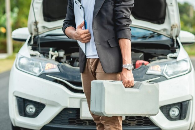 Mecánico de automóviles que viene con una caja de herramientas para ensayos de automóviles.