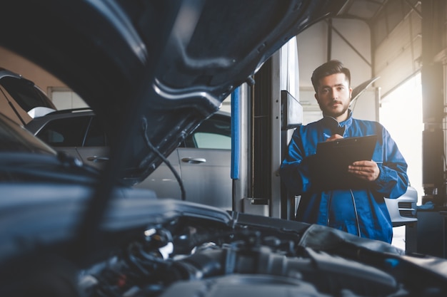 mecánico de automóviles reparando autos en el garaje de servicio