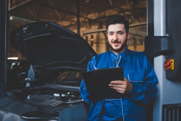 mecánico de automóviles reparando autos en el garaje de servicio