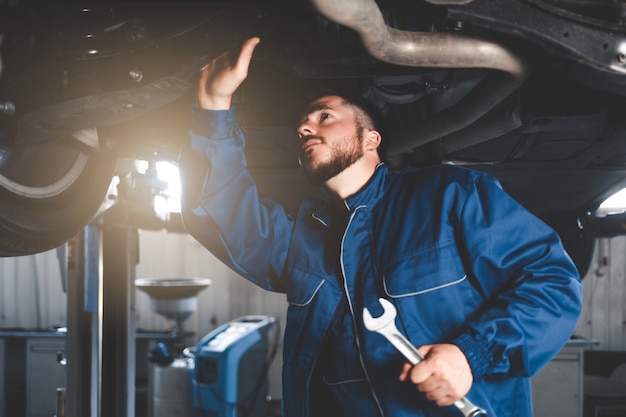 Foto mecánico de automóviles reparando autos en el garaje de servicio